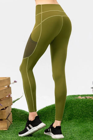 Green leggings with a subtle pattern worn by a person on a grassy background